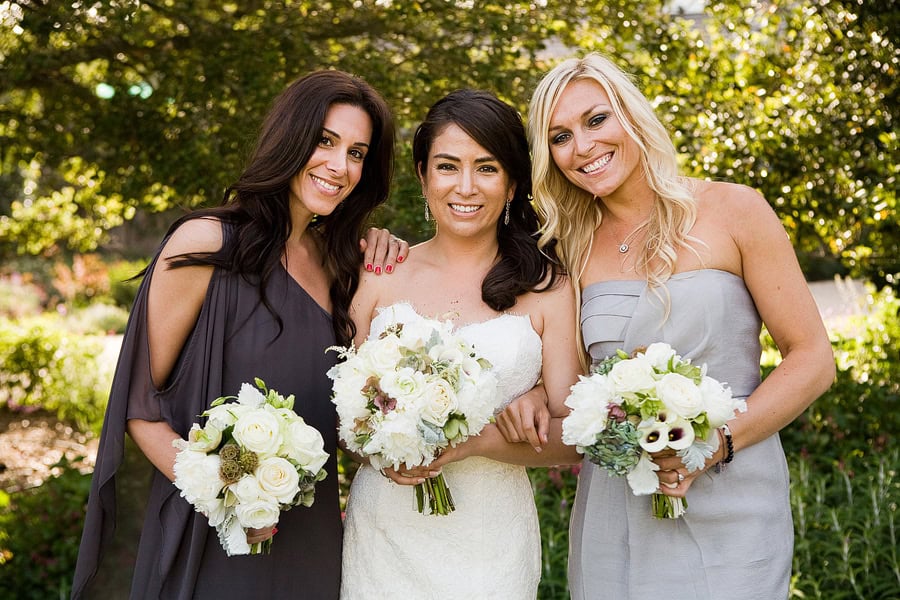 Elise and her bridesmaids holding their white bouquets