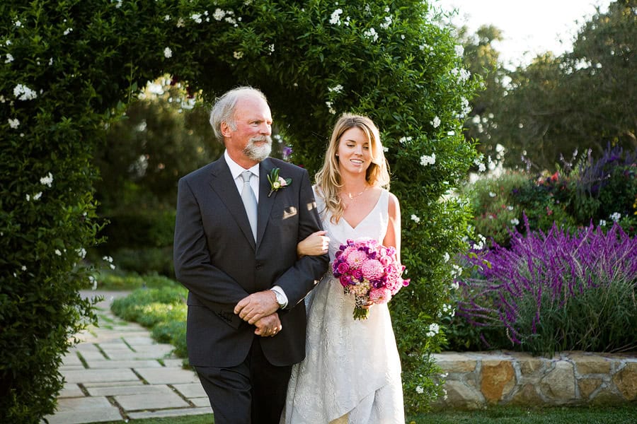 The bride, Emily and her father walking down the aisle