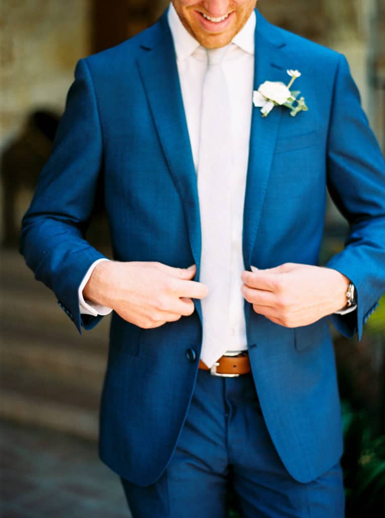 Jack buttoning up his blue suit from Atmosphere Minneapolis