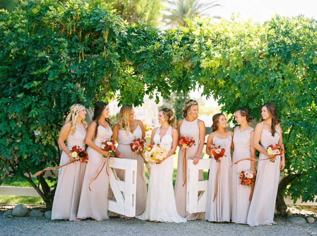 Bridesmaids wearing mauve mismatched dresses holding dark jewel toned bouquets at Mattei's Tavern