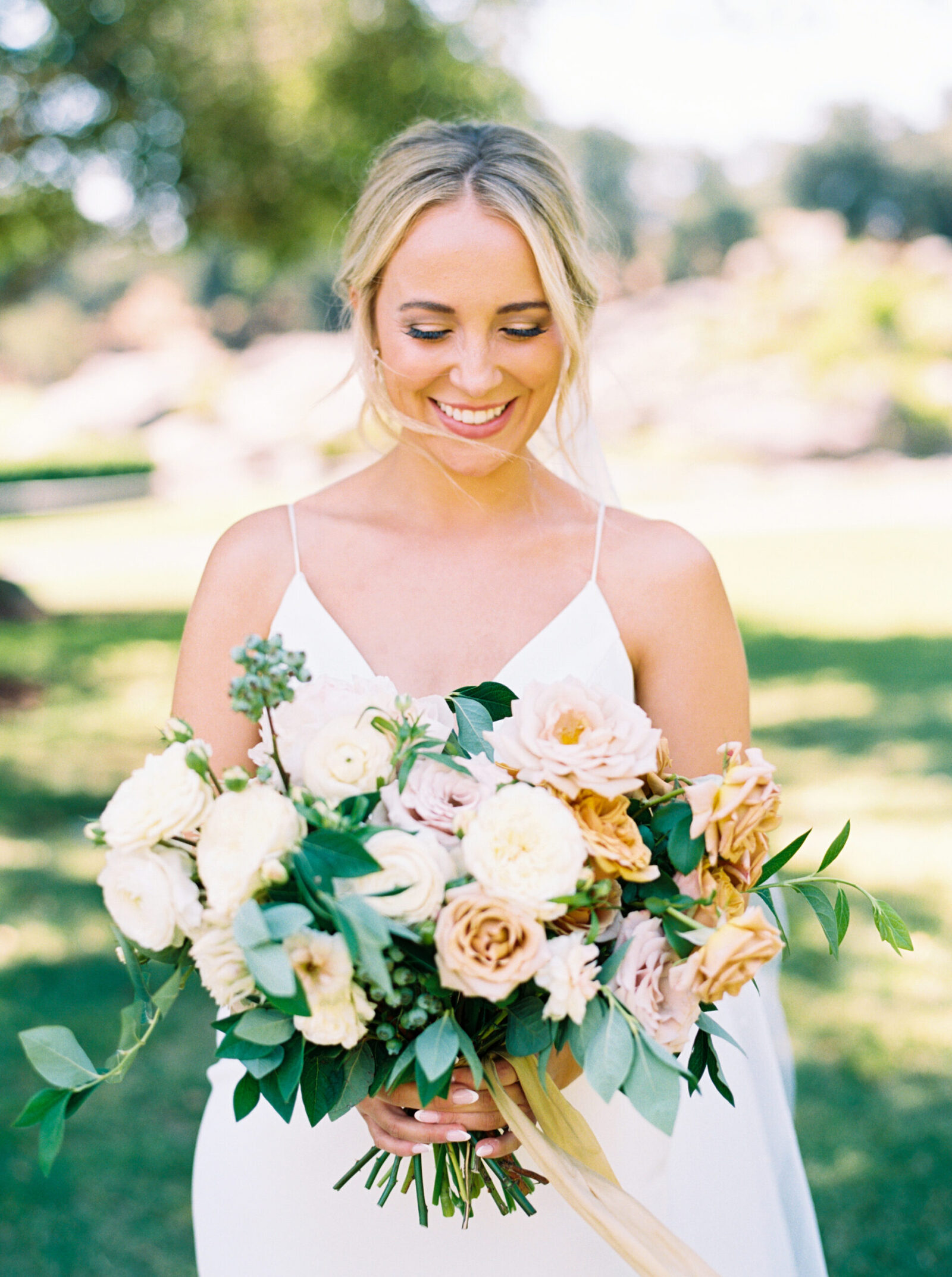 Bride glows in natural light as she poses with her lush bouquet before her wedding ceremony at Villa Loriana in San Luis Obispo.