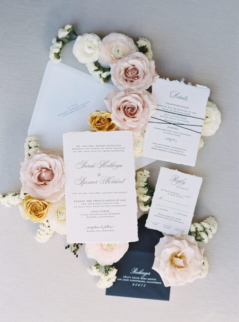 Elegant wedding invitation suite with calligraphy by Papermint Press, styled in a flat lay with fresh flowers. A sophisticated and romantic wedding stationery design captured in soft, natural light.