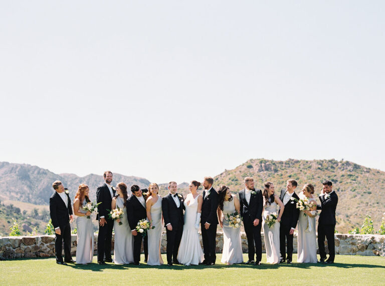 Bridal party laughing and sharing a fun moment before the wedding ceremony. Bridesmaids in elegant dresses surround the bride, capturing joyful and candid wedding day memories.