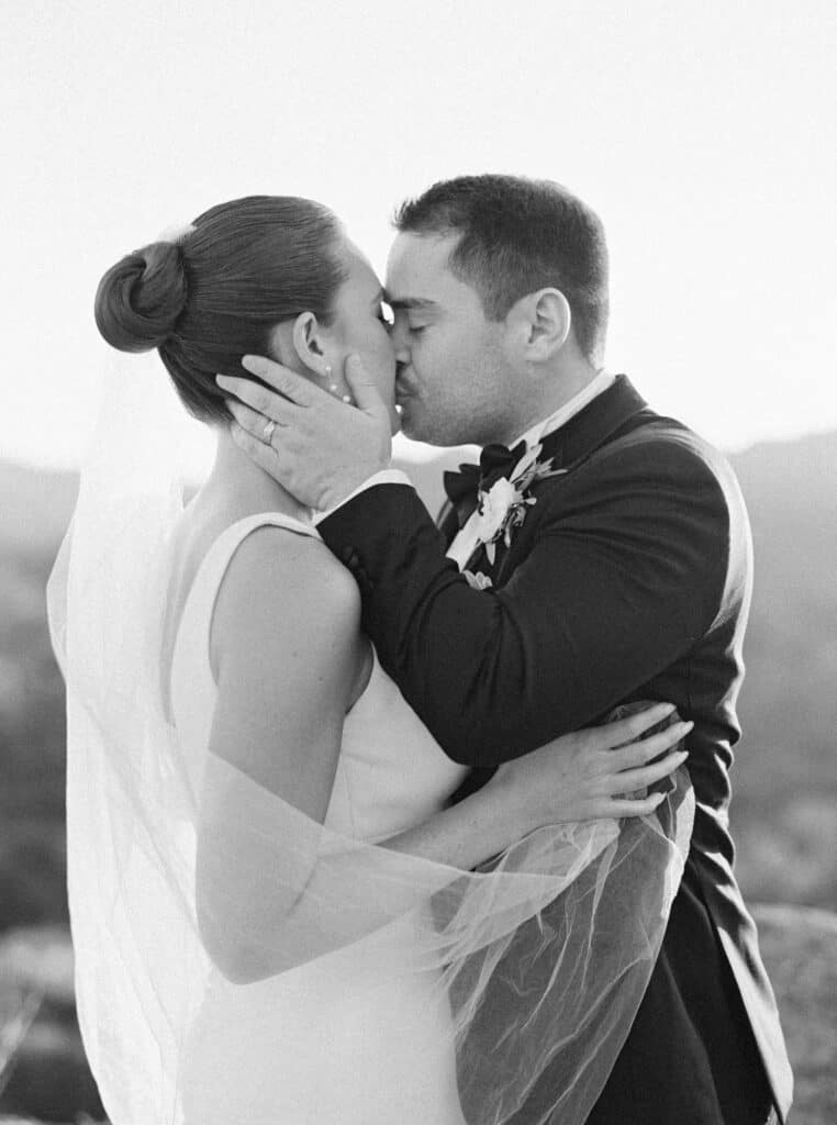 A breathtaking black and white photo of the groom pulling his bride in for a kiss, capturing a romantic and intimate moment during their wedding at Cielo Farms in Malibu.