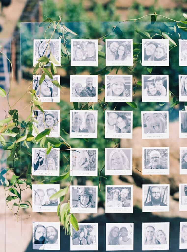 A close-up of the personalized wedding escort display at Cielo Farms in Malibu, showcasing black and white guest photos paired with elegant table assignments.