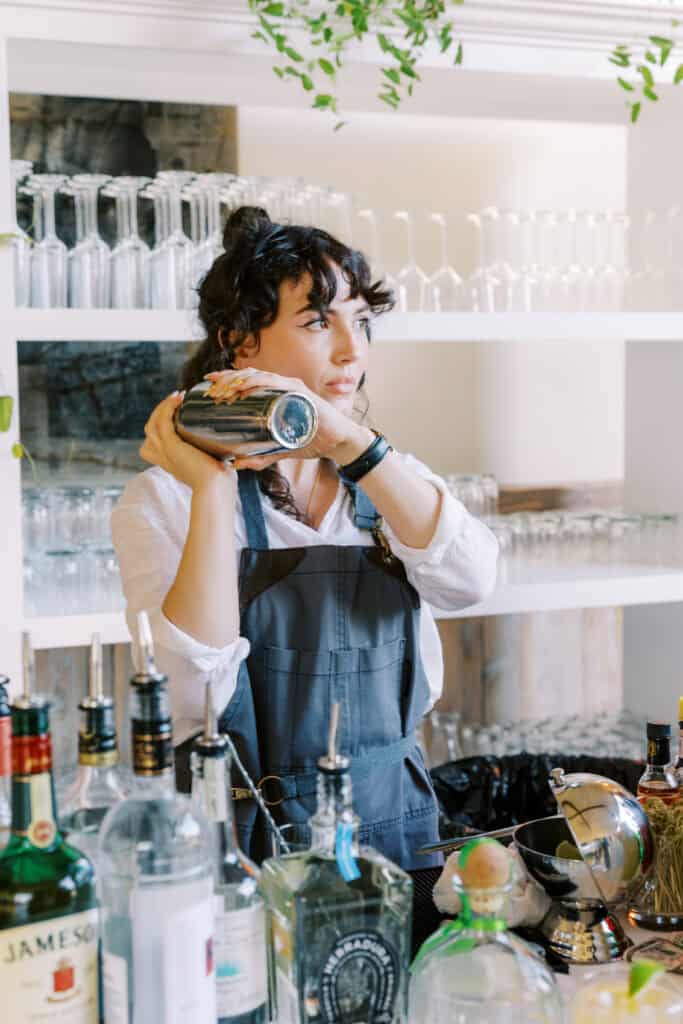 A bartender shakes up a signature drink for a guest at the wedding reception, adding a fun and interactive element to the celebration at Cielo Farms in Malibu.
