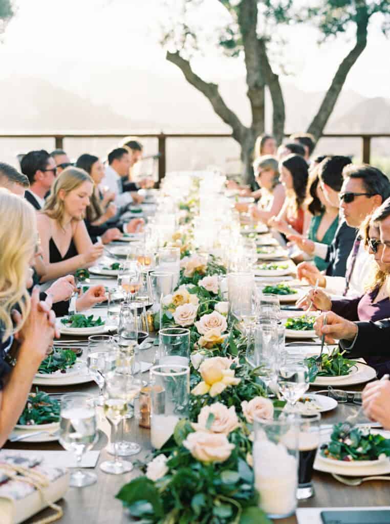 Guests seated and enjoying a beautifully plated meal created by Tres LA Group at the wedding reception, with elegant table settings and romantic ambiance at Cielo Farms.