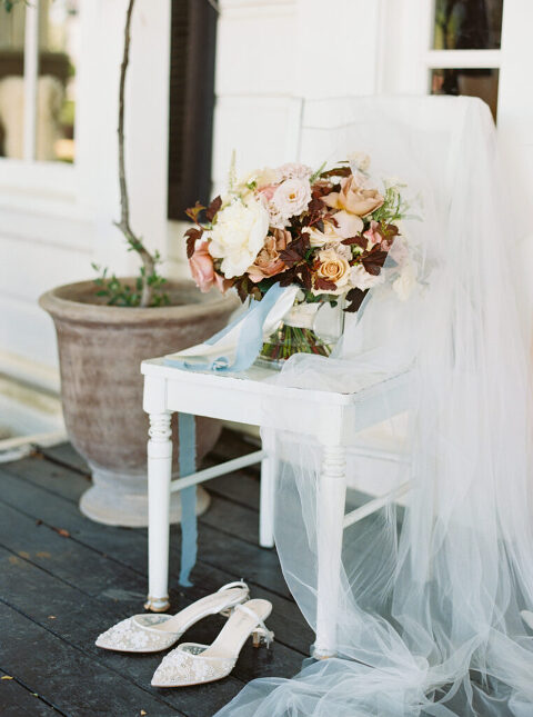 A close-up photo of the bride’s bridal bouquet by Sweet Memories Flowers, paired with her elegant wedding shoes.