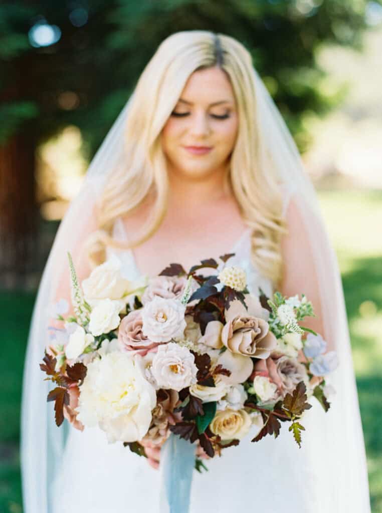 A close-up portrait of the bride highlighting her stunning bridal bouquet at her Hammersky Vineyards wedding.