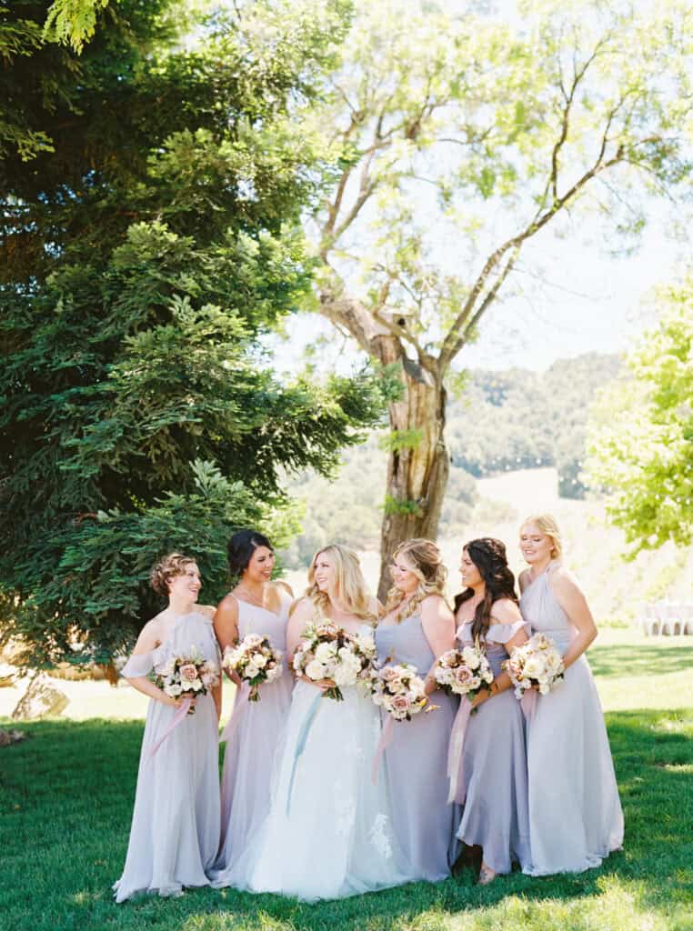 The bride poses with her bridesmaids, each holding a beautifully designed bouquet created by Sweet Memories Flowers at Hammersky Vineyards.