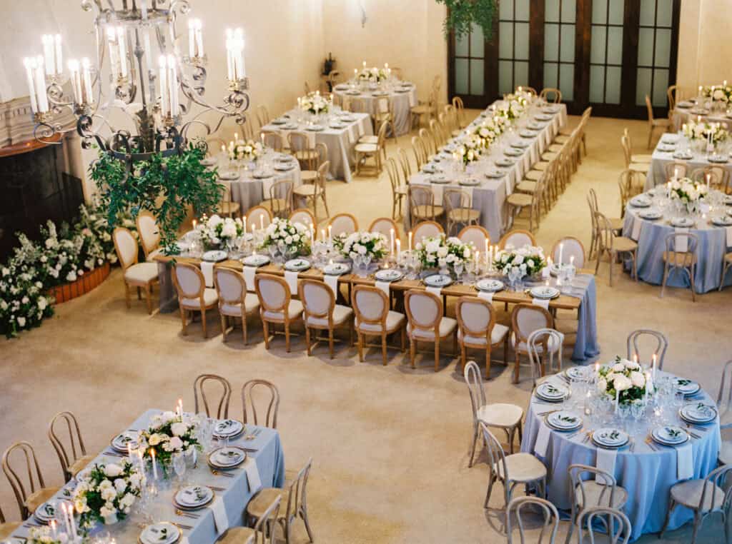 A bird's eye view of a romantic reception space at the Monterey Peninsula Country Club in Pebble Beach, designed by Charmed Events Group, showcasing elegant tables and soft lighting.