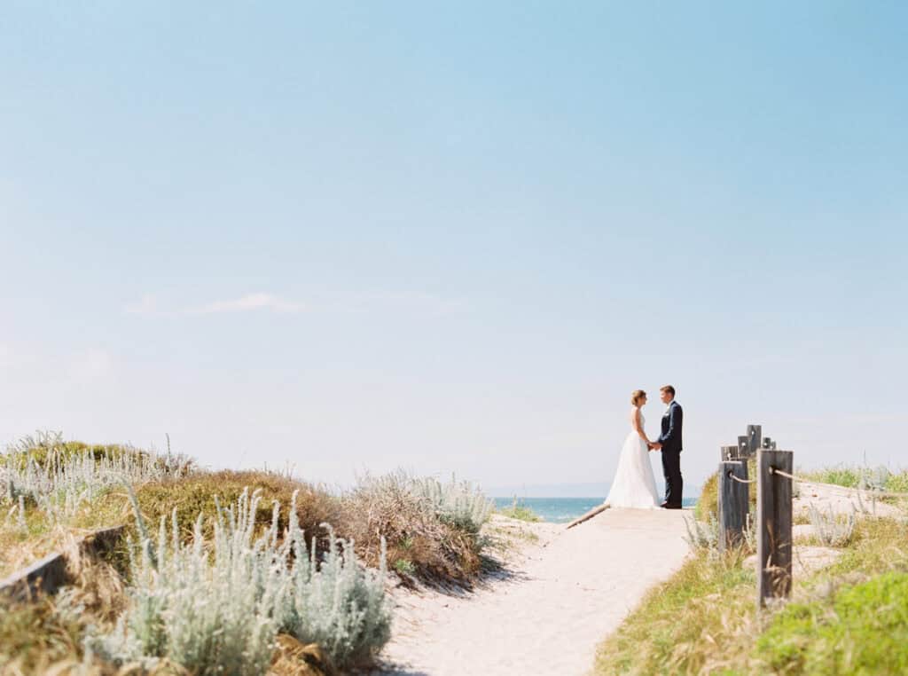 The bride and groom share a quiet moment alone on the beach at Pebble Beach, CA.