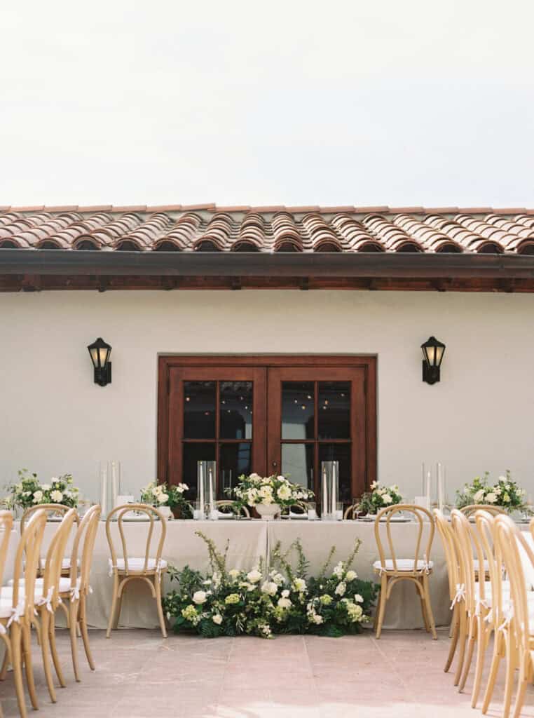 Elegant reception space at the Bacara Resort in Santa Barbara, decorated with timeless white floral arrangements and soft neutral tones, creating a romantic and sophisticated atmosphere for the newlyweds and their guests.
