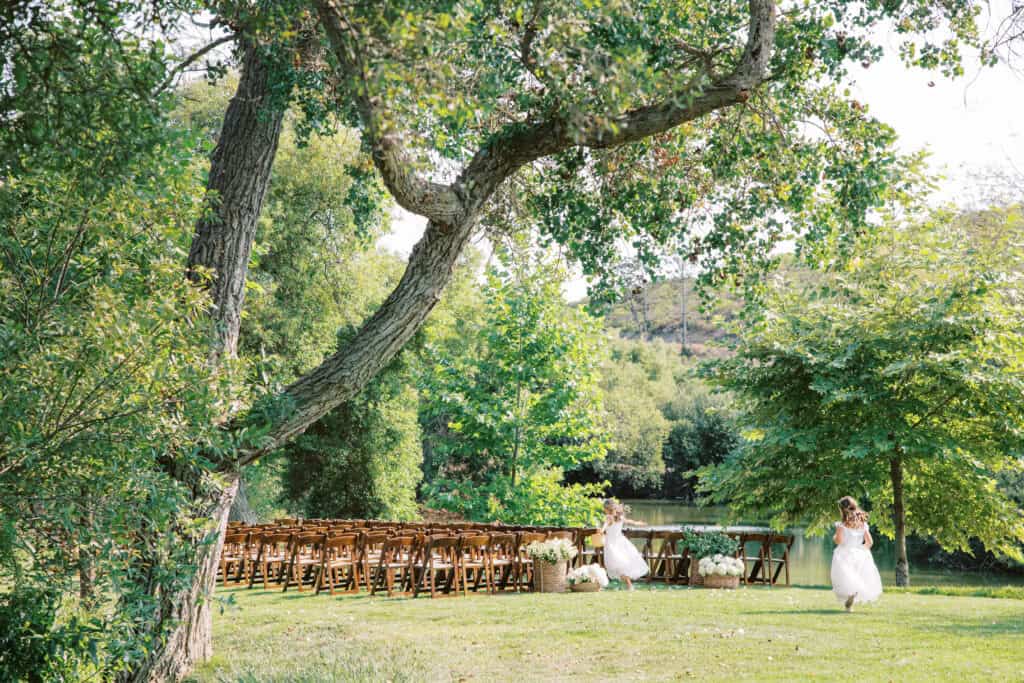 Joyful moment as the flower girls run through the aisle at Greengate Ranch after the ceremony, capturing their playful energy in the empty, serene ceremony space.