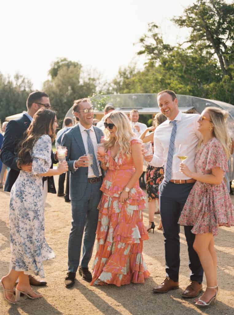 Guests laughing and enjoying cocktails during Michelle and Brendan's wedding cocktail hour at Greengate Ranch, capturing the joyful and relaxed atmosphere of their celebration.