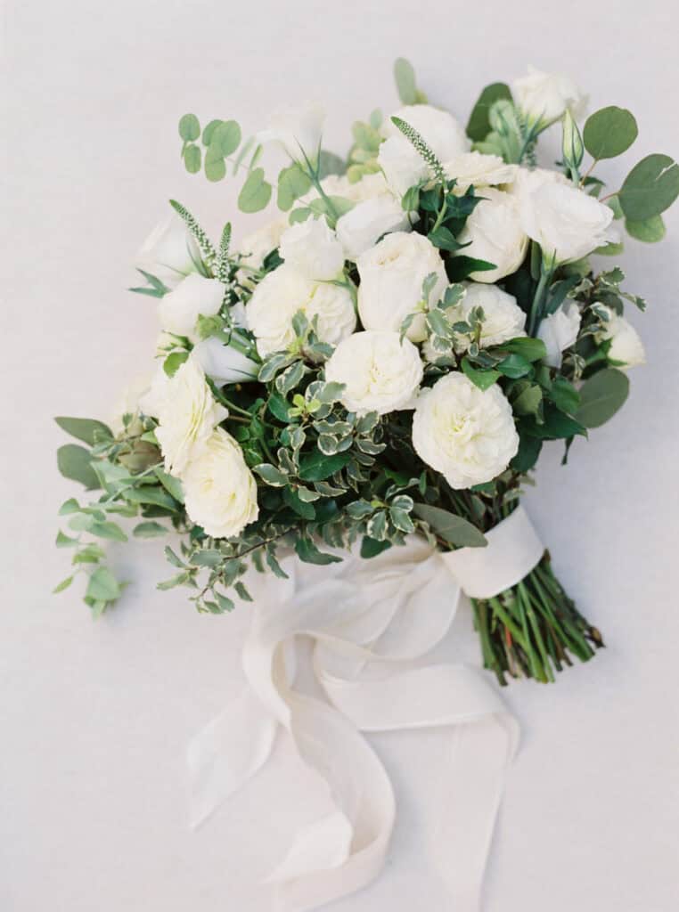 A stunning all-white bridal bouquet featuring lush roses and delicate blooms, captured at a private estate wedding in Lodi, CA.