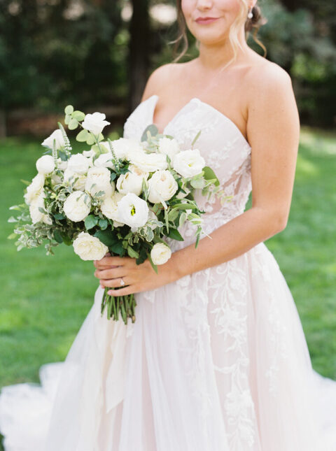 A close-up photo of the bride holding a stunning all-white bridal bouquet at her private estate wedding in Lodi, CA. The bouquet features lush blooms in a classic, elegant design.