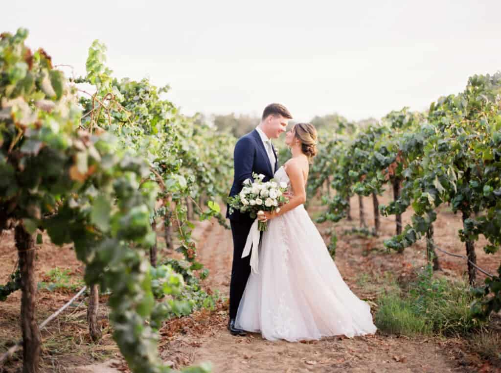 The newlyweds stand in the middle of the vineyards, gazing deeply into each other’s eyes at their private estate wedding in Lodi, CA.