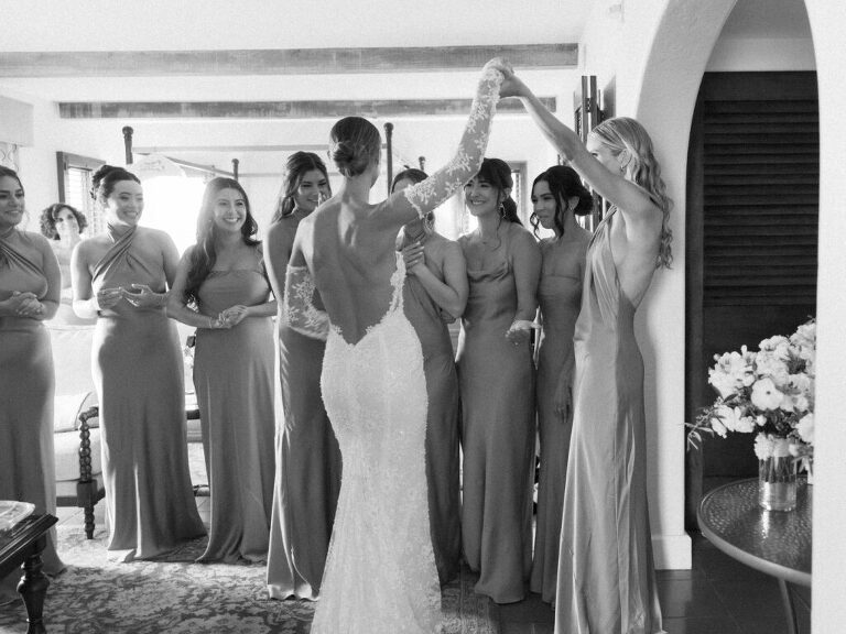 Bride shows off her wedding dress to her bridal party in a private suite at the Bacara Resort