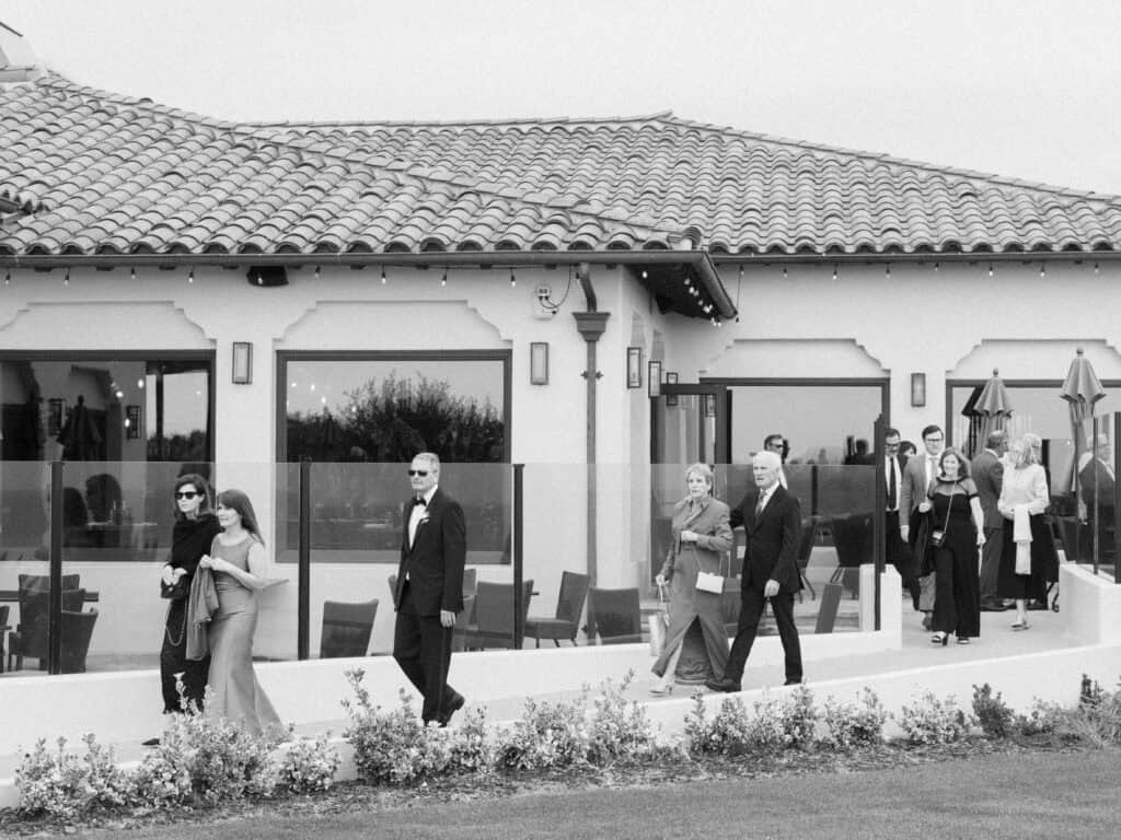 Black and white photo of guests entering the ceremony lawn at the Bacara Resort. 