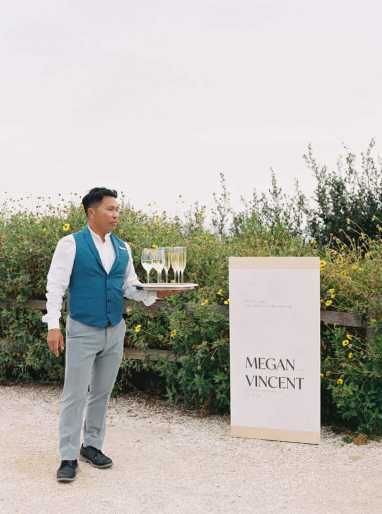 Waiter holding a tray of champagne for guests to enjoy before the ceremony at a wedding in Santa Barbara, captured by Jen Rodriguez Photography.
