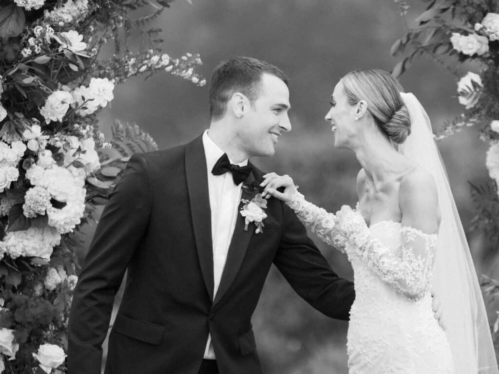 Joyful black and white photo of newlyweds, bride and groom, celebrating their first moments as husband and wife at their wedding ceremony at the Bacara Resort, Santa Barbara.