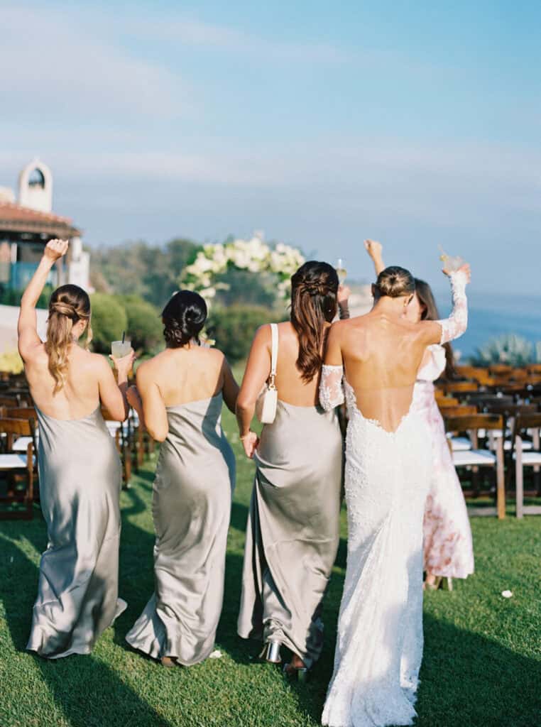 A fun moment with a bride and her bridesmaids as they celebrate holding their drinks in the air. 